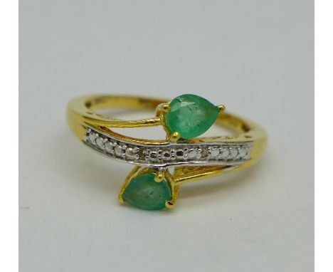 A silver-gilt emerald ring with diamond accents, size Q