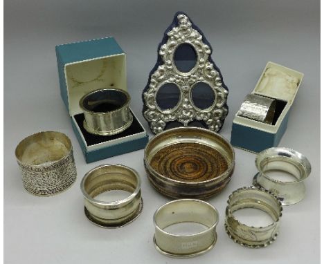 Seven silver napkin rings, a small silver coaster and a silver triple portrait photograph frame, weight of napkin rings 137g,