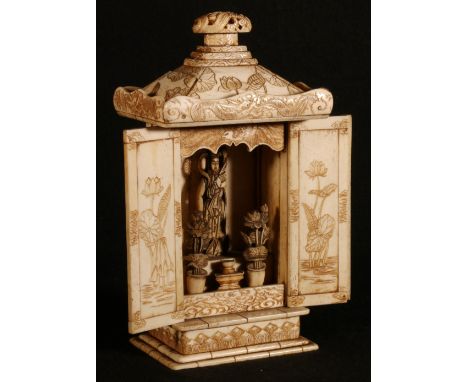 Japanese bone shrine, the two doors opening to reveal a figure of Kwannon, lily decorated shrine top with dragon surmount, pl