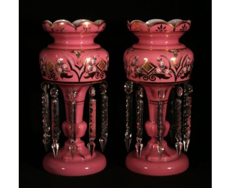 Pair of jewelled pink glass table lustres or girandoles decorated with gilt floral scrolls each with ten dependant faceted dr