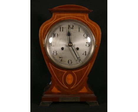 Edwardian Art Nouveau mahogany and inlaid mantle clock with silvered dial, presentation plaque and raised on brass supports, 