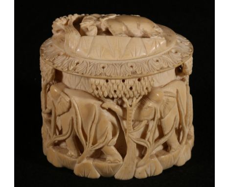 Early 20th century heavily carved African ivory box and cover the lid and body carved with elephants, 10cm high, 10.5cm wide 