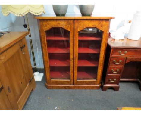 A Victorian burr walnut bookcase, two doors opening to reveal lined shelf space, twin interior base drawers, canted plinth ba