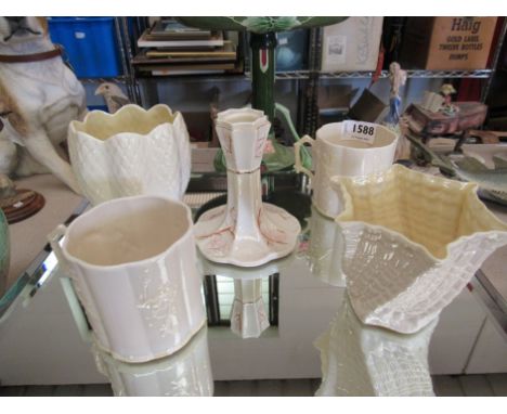 Five pieces of Belleek china including a pair of mugs and a candlestick (5)