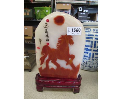 An Afghan jade slab with horse depiction on a wooden stand, overall height 25.5cm