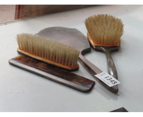 A silver backed four piece dressing table set, brushes, mirror and comb