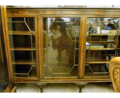 A 1920s mahogany display cabinet, having a low upstand and a shelf top with a rope carved and Vitruvian scrolled border, over