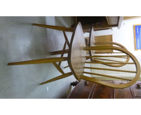 A set of four Ercol beech and elm framed, hoop and spindle back dining chairs, the solid seats raised on tapered legs       B