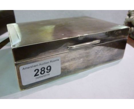 A silver cigarette box, having a hinged lid with engine turned decoration  Birmingham 1957  7''w        S