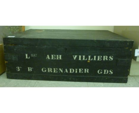 An early 20thC black painted pine trunk with steel reinforcement and recessed flank handles, inscribed 'Leut. AEH Villiers 3r
