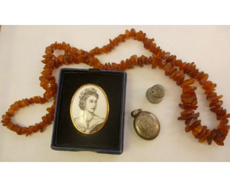 A white coloured metal oval, hinged locket; a Sterling silver thimble; an amber coloured 'rough cut' bead necklace; and a Roy