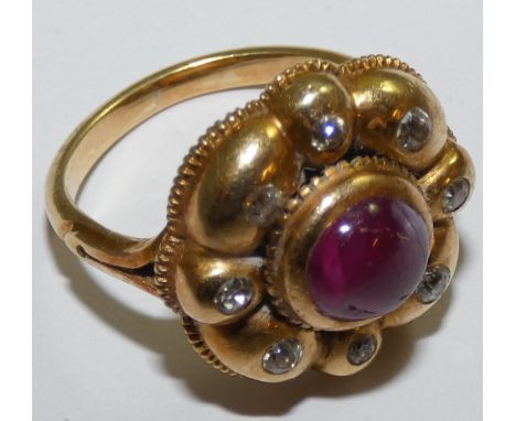 A Victorian ruby and diamond cluster ring, collet set with a cabochon stone, bordered by old cuts, total diamond weight appro