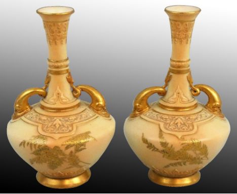 A Royal Worcester pair of blush ivory porcelain dolphin-handled vases, gilt and polychrome enamel foliage, puce date code 189