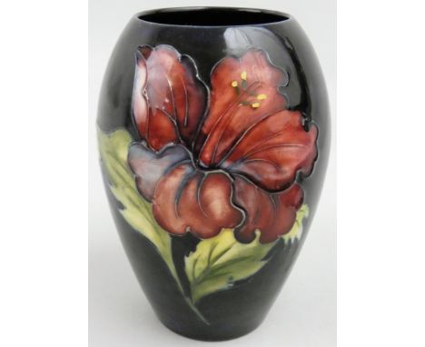 A Moorcroft Lily pattern vase, on a blue ground, the paper label reads "By appointment W. Moorcroft Potters to the late Queen