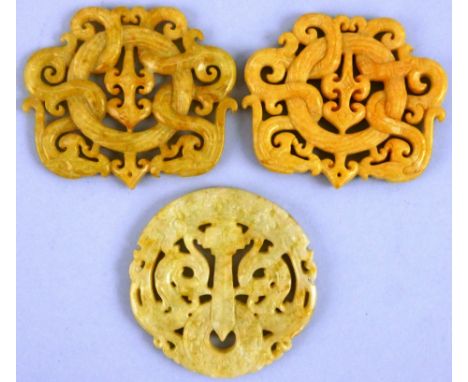 A pair of Chinese sand coloured jade panels, with pierced and engraved dragon decoration, 7 x 6 cm and a similar circular pan