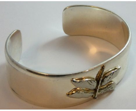A silver bangle with an applied dragonfly, the inside stamped c.1997, Tiffany &amp; C0., 925, width 21 mm, weight 61 gms.