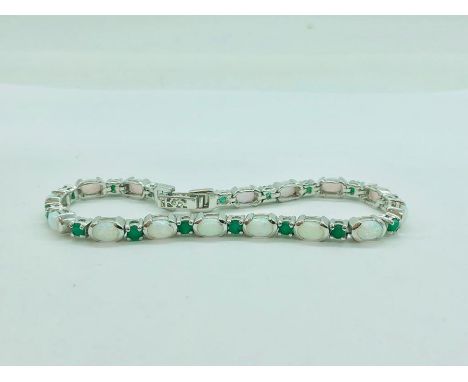 A silver line bracelet set with emerald and opal panels 