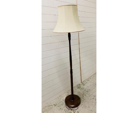 A mahogany turned standard lamp with cream shade 
