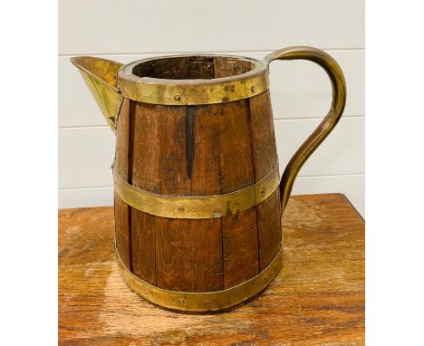 A large wooden barrel pitcher with brass hoops  