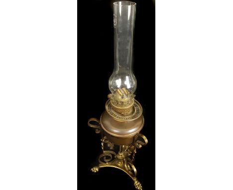 A Victorian scrolled brass and copper oil lamp, on trefoil base with lion pad feet, the oil bowl of copper, with Duplex burne