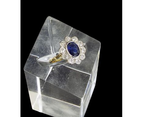 18ct sapphire and and diamond oval cluster ring, the oval-cut sapphire in a surround of ten round-brilliant-cut diamonds, 1ct