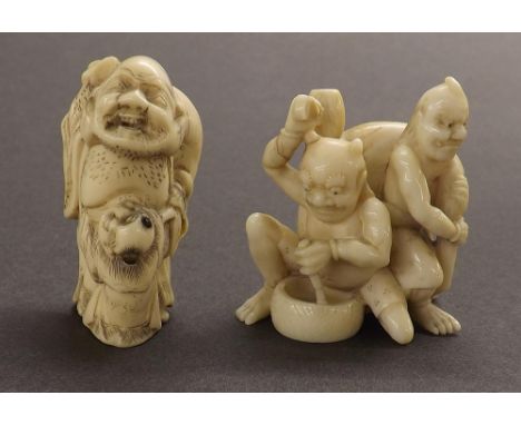 Japanese ivory netsuke modelled with two Oni, signed, 1.75" high; together with another netsuke (2)