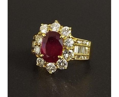 (537398-1-A) Good 18ct ruby and diamond oval cluster ring, the oval cut ruby in a surround of round brilliant and baguette-cu