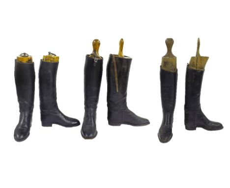 Three pairs of vintage black leather riding boots, all fitted with wooden trees