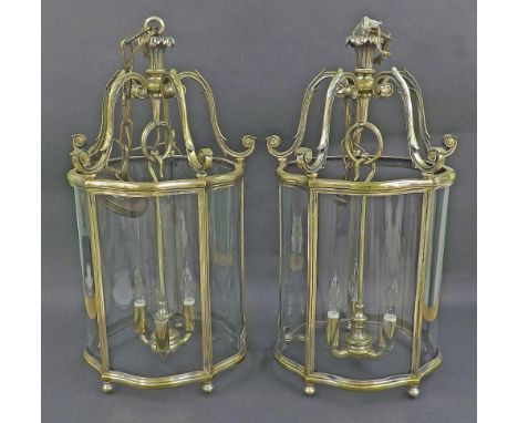 Pair of cast brass serpentine hanging hall lanterns, with five panels enclosing a three branch light, 26" high without chain 