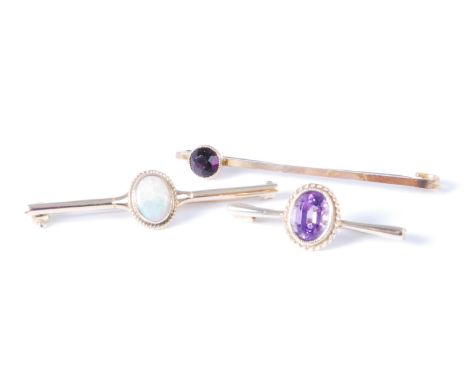 A 9ct gold cabochon opal set bar brooch, 4.3cm; together with a yellow metal amethyst set safety pin brooch; and an amethyst 