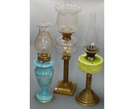 A Victorian oil lamp, having frilled glass shade above a clear glass font, on brass column and stepped square base; together 