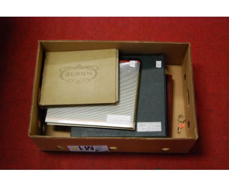 An album of postcards, to include the British Army series; and three other postcard albums