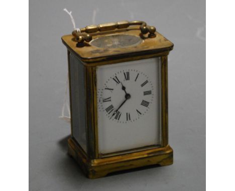 An early 20th century lacquered brass cased carriage clock having enamel dial with Roman numerals and visible platform escape