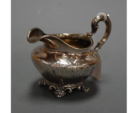 A Victorian silver cream jug, having floral engraved decoration and vacant cartouche, with flying C-scroll handle, maker Edwa