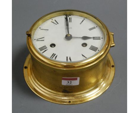 A continental brass cased ships bulkhead clock, the circular enamelled dial with Roman numerals and eight day movement, signe