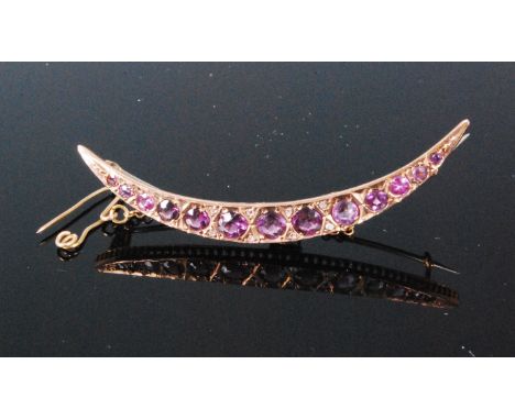 An early 20th century 9ct gold and amethyst set crescent brooch with safety chain, 3g, 5.5cm. Several of the stones have chip