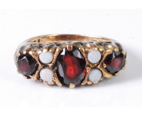 An Edwardian style 9ct gold, garnet and opal set dress ring, size L, 3.6g