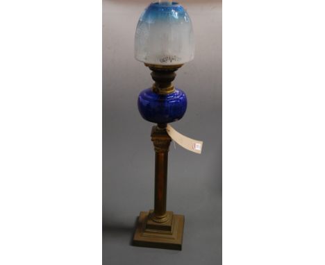 A Victorian oil lamp, having a blue tinted etched glass shade above a blue glass font, on brass Corinthian column and stepped