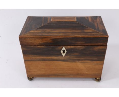 William IV coromandel tea caddy, of sarcophagus form with flanking mask handles on ball feet, the hinged top enclosing twin l