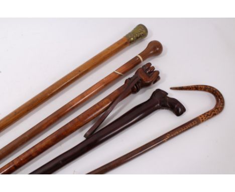 Novelty carved hardwood stick, with carved shoe handle, 83cm long, together with 19th century malacca cane with embossed bras