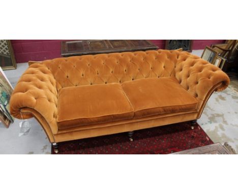 Fine quality chesterfield sofa by Fleming and Howland, copper coloured velvet button upholstery on turned legs and brass capp