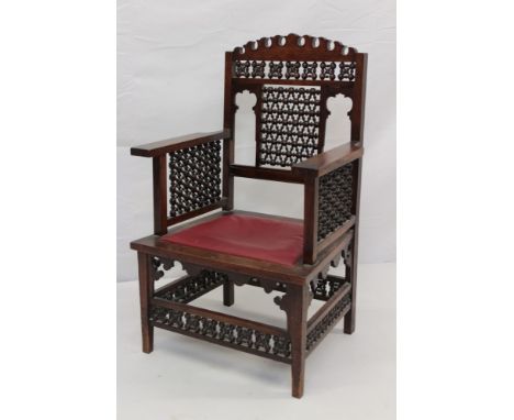 Early 20th Century Moorish style mahogany open arm chair, in the manner of Libertys, square lattice bobbin back and side pane