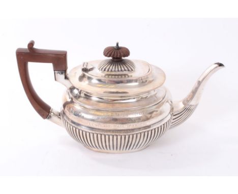 Late Victorian silver teapot of half fluted form, with angular handle and hinged domed cover, on an oval base (London 1899) R