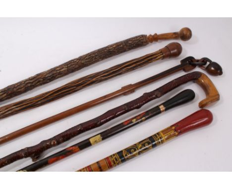 Unusual group of antique walking sticks, including Indian painted stick, transfer printed stick with gilt collar, carved bark