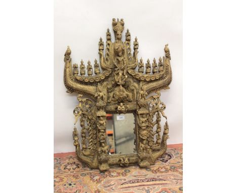 Ornately carved Tibetan giltwood wall mirror, square plate within elaborate architectural frame with repeat figural motifs, t