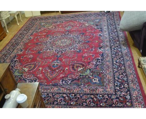 A Tabriz carpet, the centre medallion enclosed within a scalloped scrolling border, with floral sprays and lotus leaf and flo