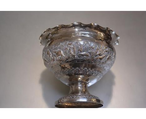 An Indian plated chased scalloped border rose bowl decorated with scenes of hunting and tigers, lions etc. raised on circular