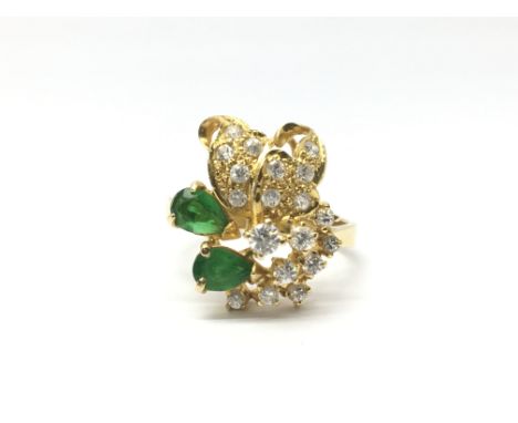 A ladies 18ct gold ring set with CZ's and two emeralds, ring size O/P, weight approx 5 grams.