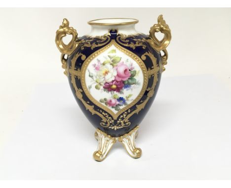 A Royal Crown Derby Porcelain vase with hand painted panels of flowers signed C Gresley. With applied gilt on a deep blue gro