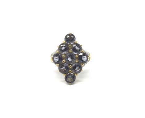 A ladies 9ct gold ring profusely set with large purple stones in a diamond formation, the shoulders set with diamonds. Total 